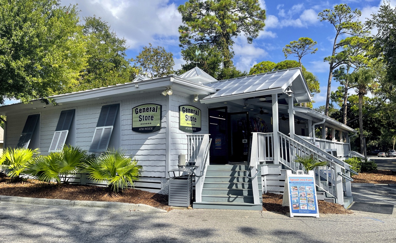 Charming coastal general store nestled among lush trees, featuring classic architecture and convenient on-site shopping for essentials.
