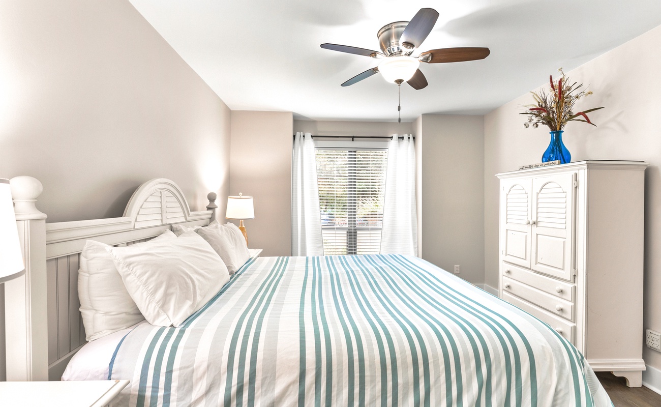 Drift off in your coastal-inspired retreat with soft linens, gentle ceiling fan breeze, and soothing seaside colors.