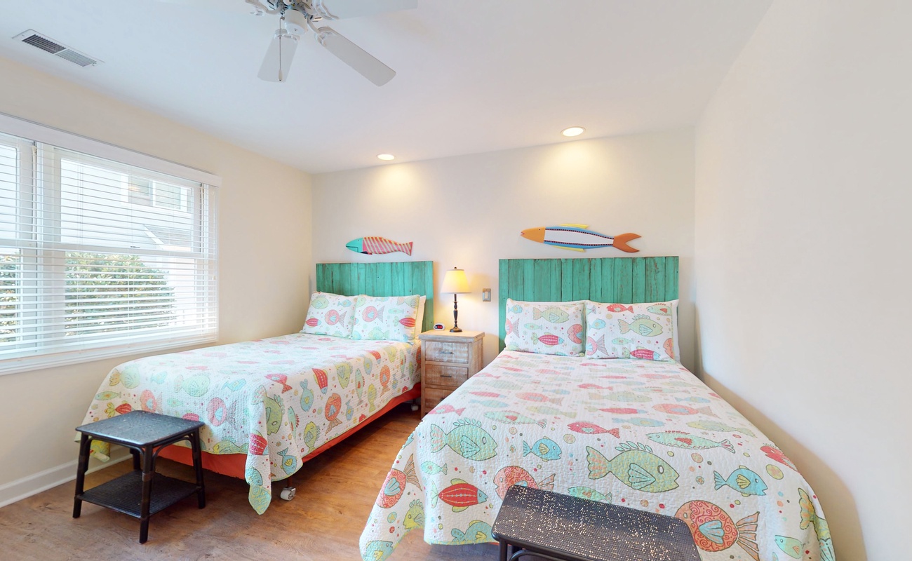 Dive into comfort in your twin bedroom featuring whimsical fish-themed bedding and turquoise headboards that transport you to an underwater paradise.