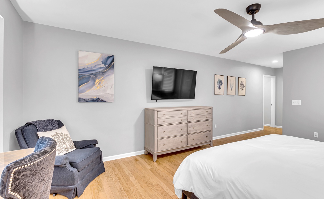 Your serene bedroom features a cozy reading chair, flat-screen TV, and ample storage in this thoughtfully appointed space.