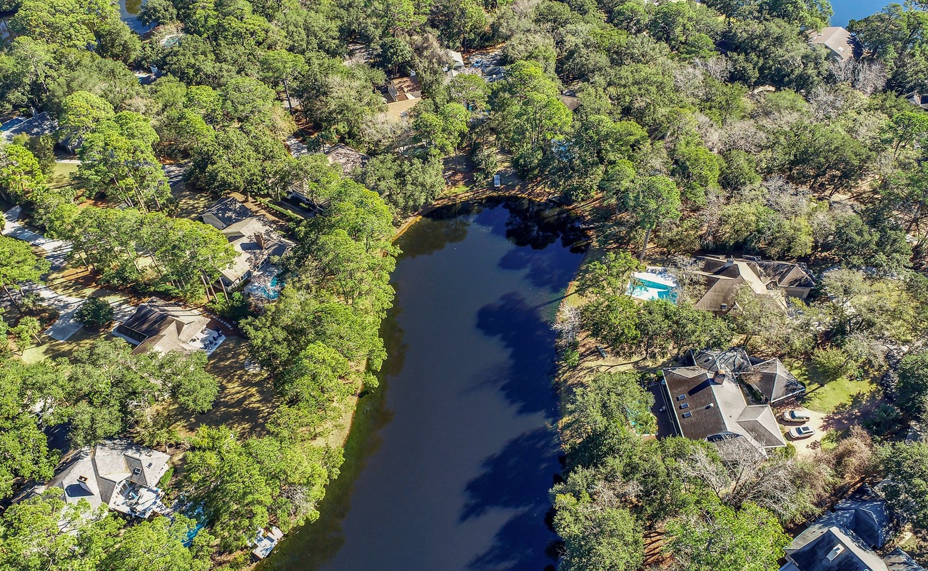 Stunning lakefront community nestled among mature trees with peaceful water views and private pools throughout the wooded neighborhood.