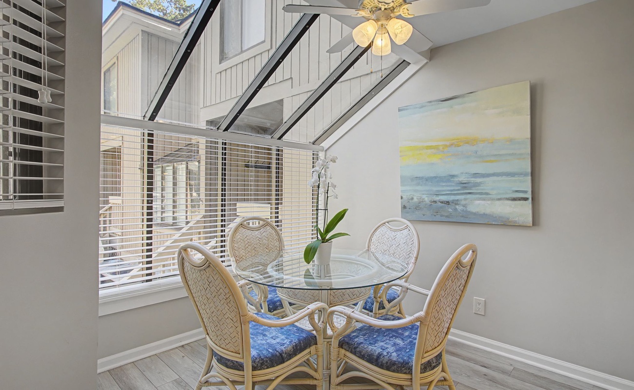 Savor your morning coffee at this charming coastal-themed dining nook with serene artwork and natural light streaming through.