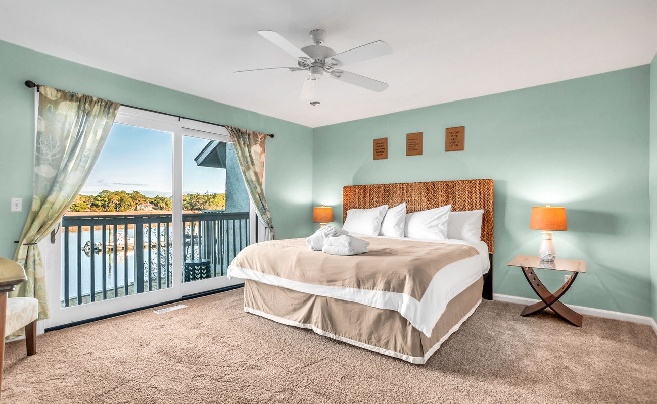 Wake up to stunning water views from your peaceful bedroom sanctuary, where soft mint walls and cozy furnishings create the perfect retreat.