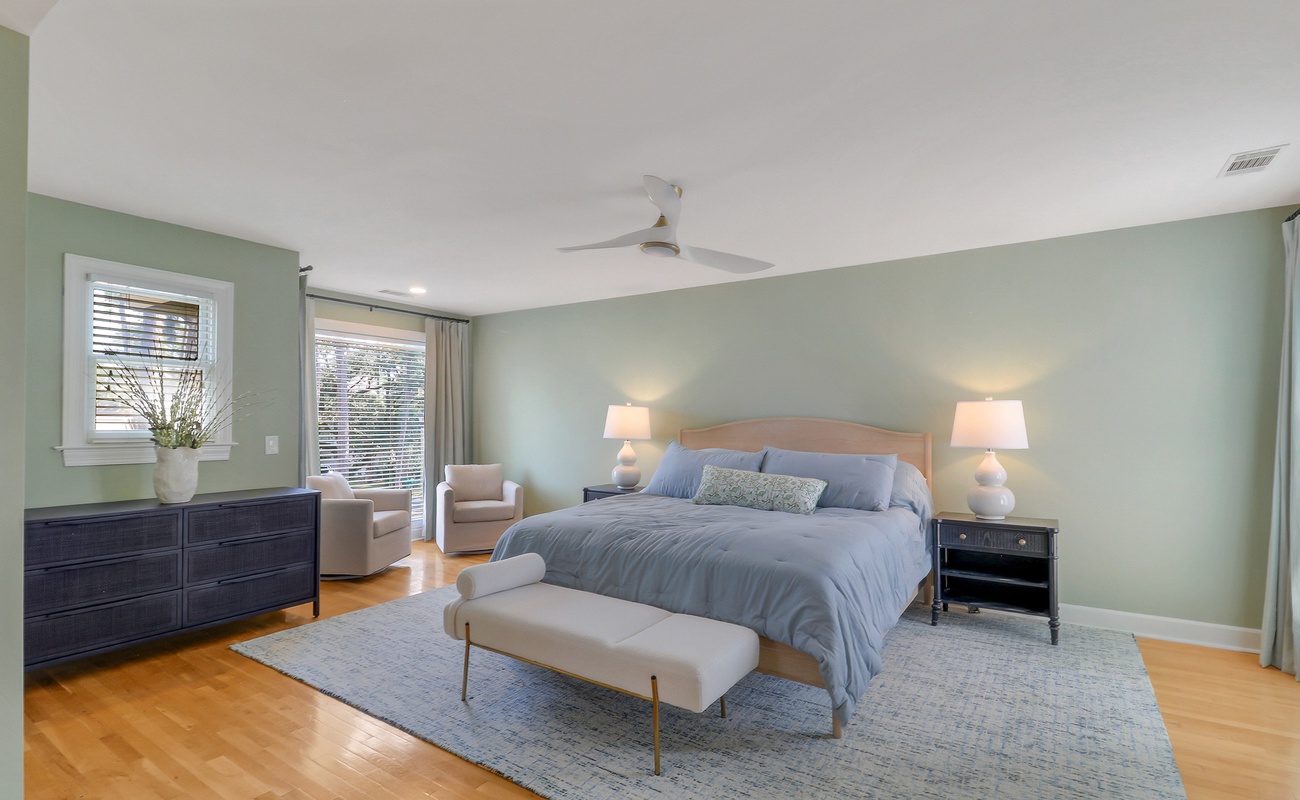 Unwind in your spacious bedroom with calming sage walls, plush bedding, and gentle ceiling fan creating the perfect retreat.