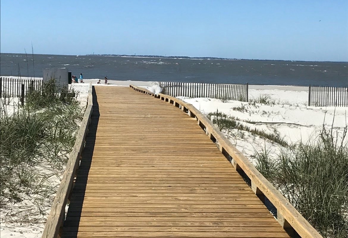 A scenic wooden boardwalk leads directly to pristine beach access, offering stunning coastal views and convenient pathways to sandy shores.