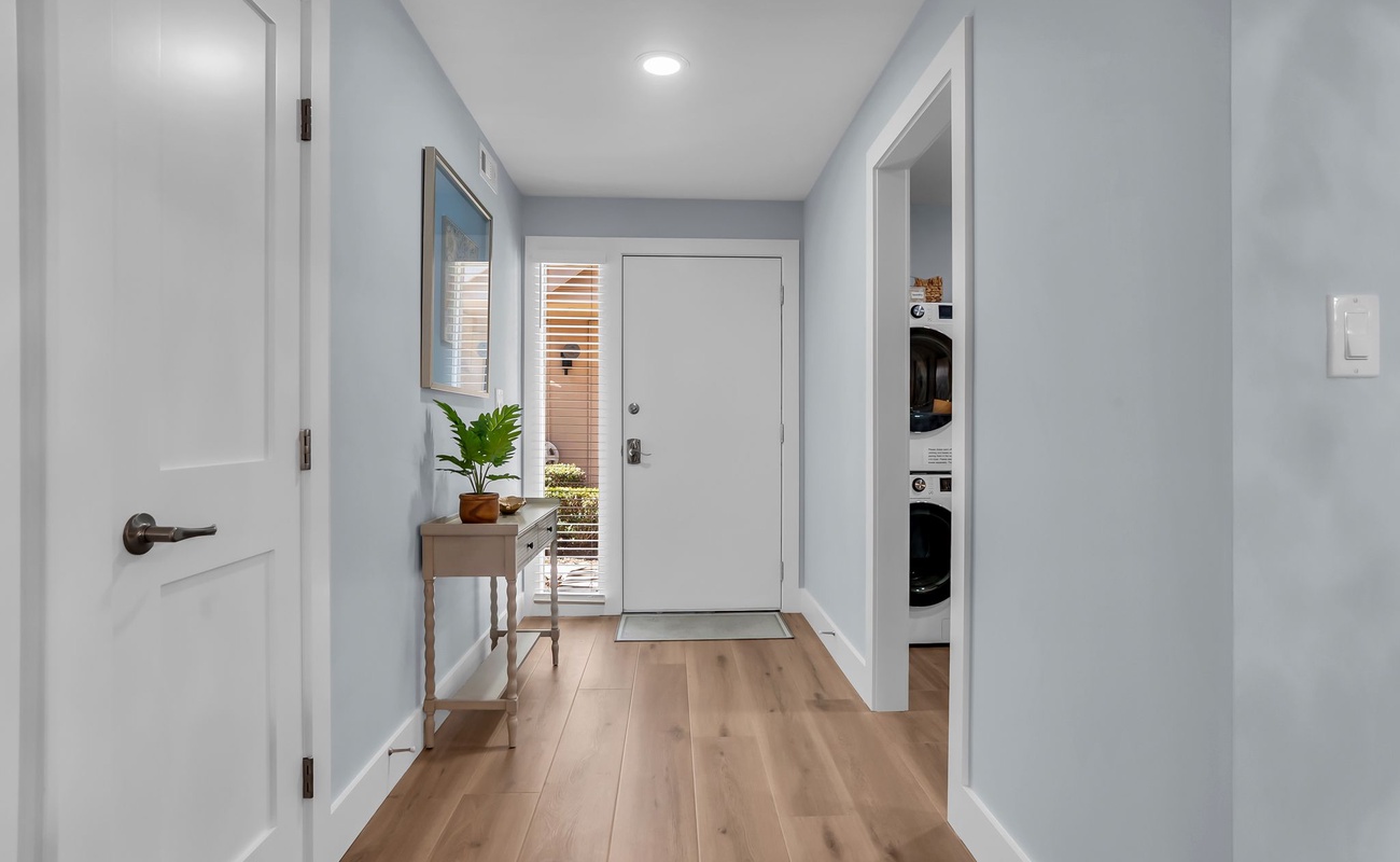 Step into your bright, welcoming entryway with gleaming hardwood floors and soothing blue walls that create an instantly calming atmosphere.