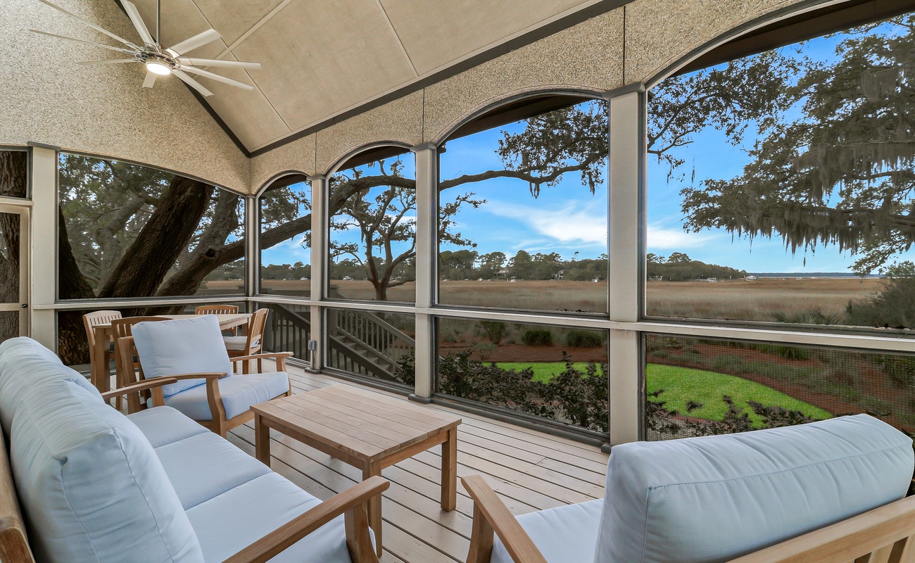 Relax in your screened porch with stunning marsh views, comfortable seating, and gentle ceiling fan breezes.