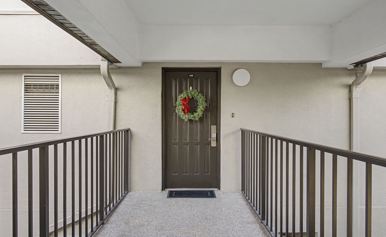 Welcoming entrance with festive wreath greets you at your private front door, complete with covered walkway for comfortable arrivals.