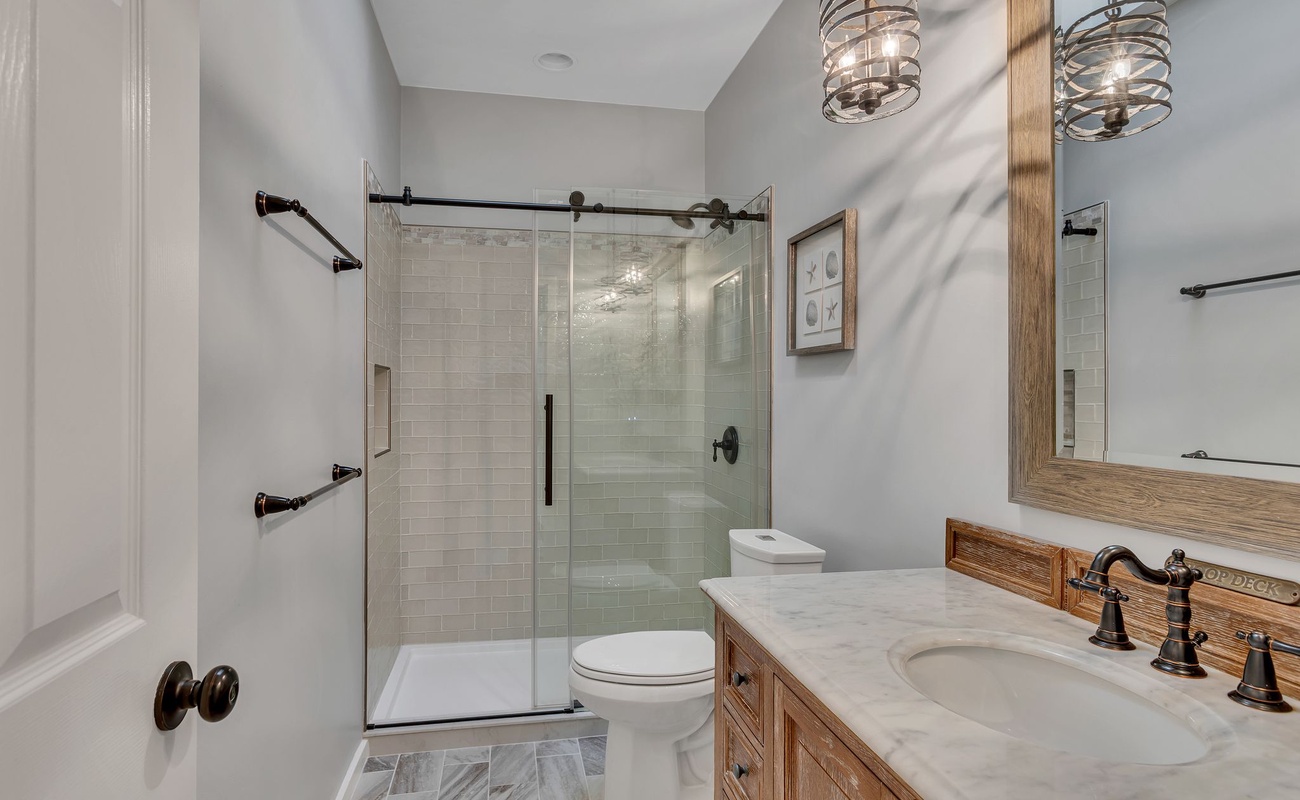 Step into your serene bathroom sanctuary with a luxurious walk-in shower, elegant marble countertops, and warm wood vanity perfect for your morning routine.