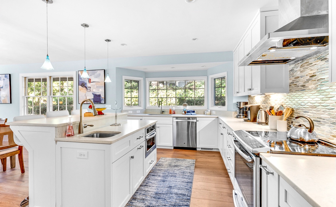 Your gourmet kitchen awaits with gleaming countertops, professional appliances, and abundant natural light streaming through garden windows.