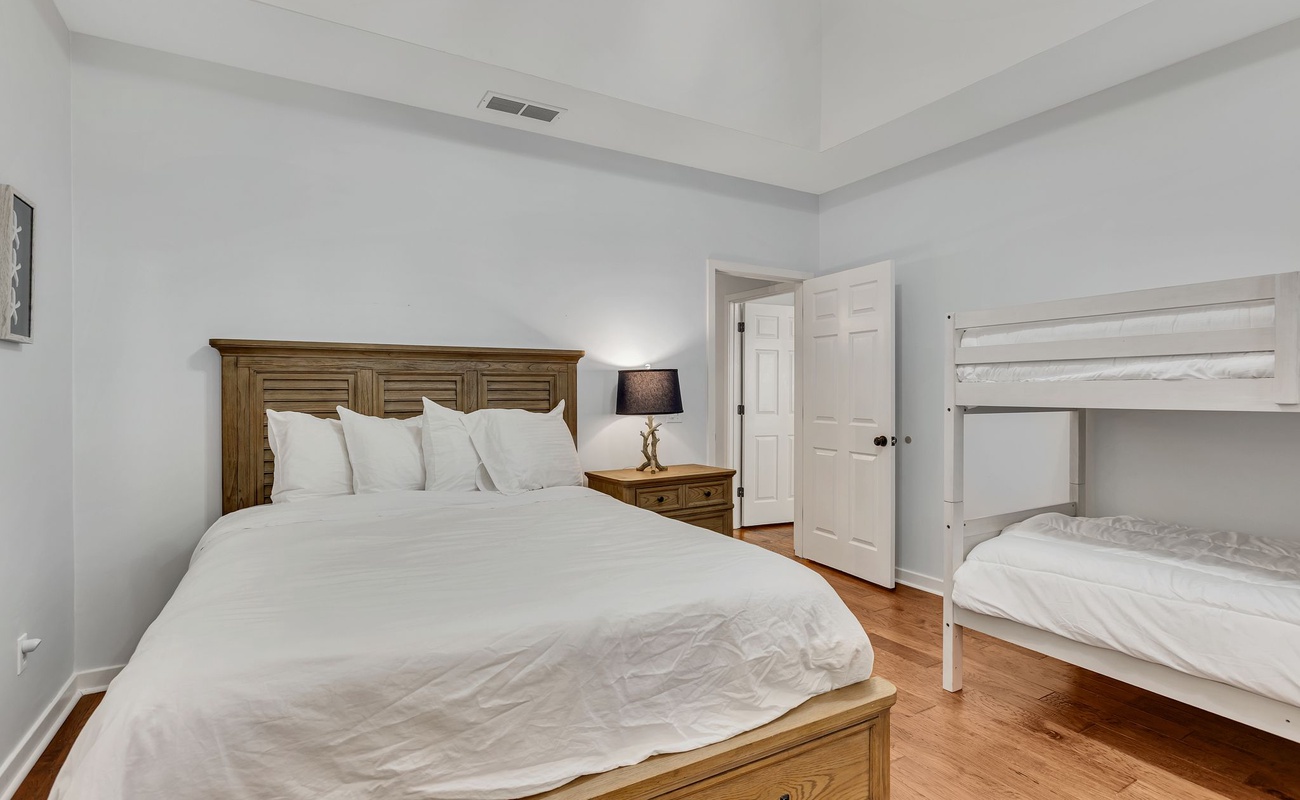 Slip into crisp white linens in your spacious bedroom, where warm wood floors and cozy furnishings create the perfect retreat.