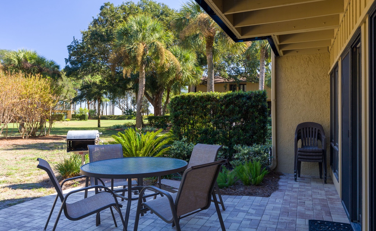 Relax at your private patio table surrounded by lush palm trees and peaceful garden views—perfect for morning coffee or evening conversations.
