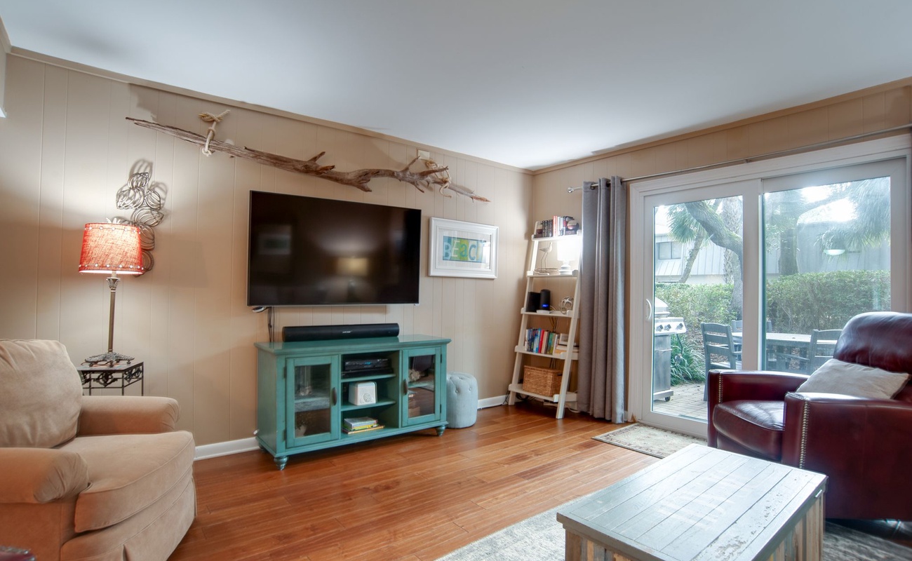 Unwind in your cozy living room with comfortable seating, flat-screen TV, and sliding doors opening to your private outdoor patio space.