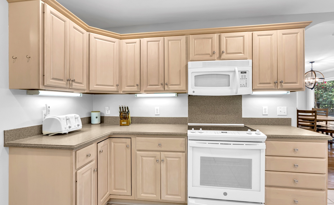 Your fully equipped kitchen features warm wood cabinetry, granite countertops, and modern appliances for comfortable home-away-from-home cooking.