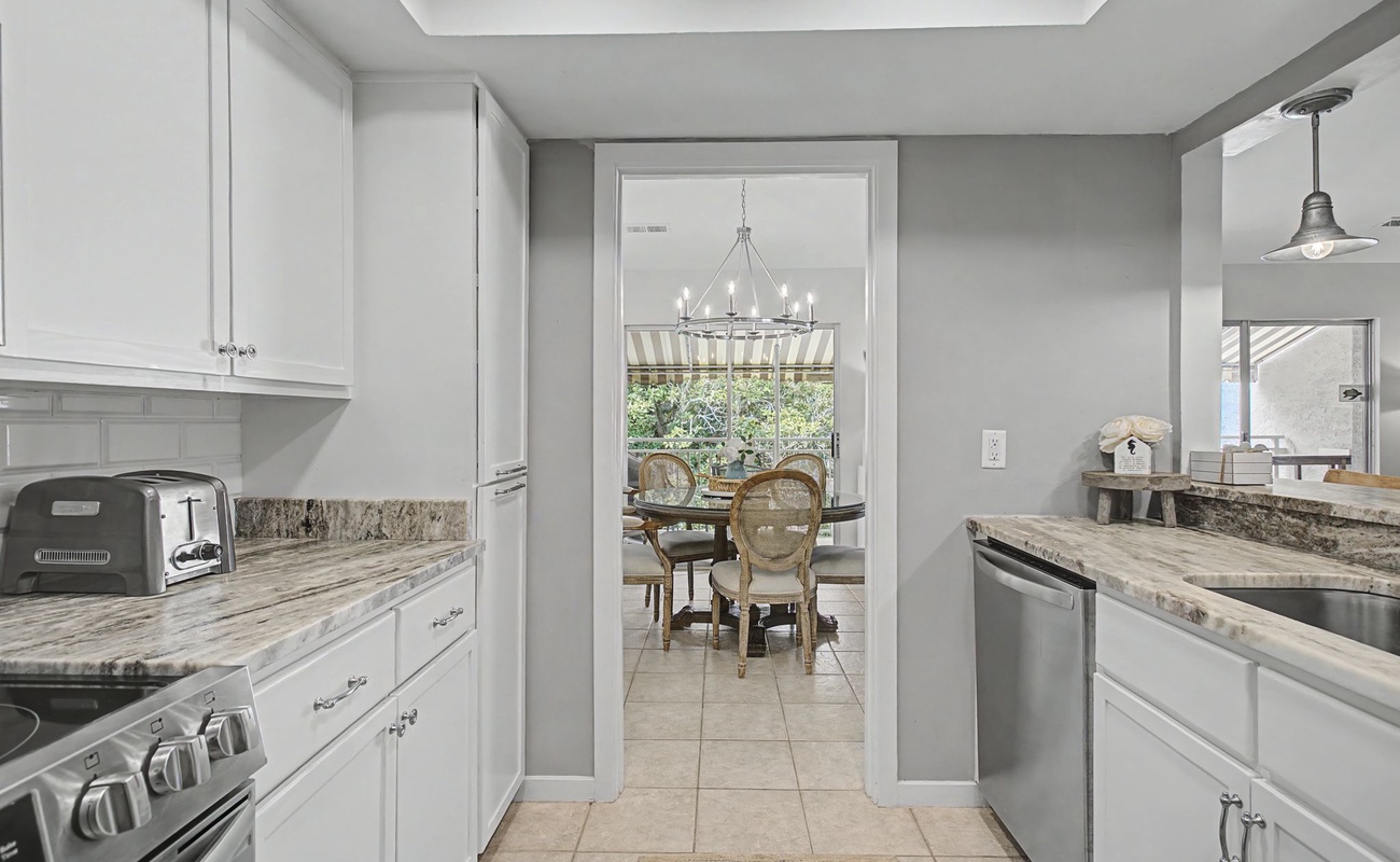Your gourmet kitchen awaits with granite counters, stainless appliances, and elegant white cabinetry—perfect for creating memorable meals during your stay.