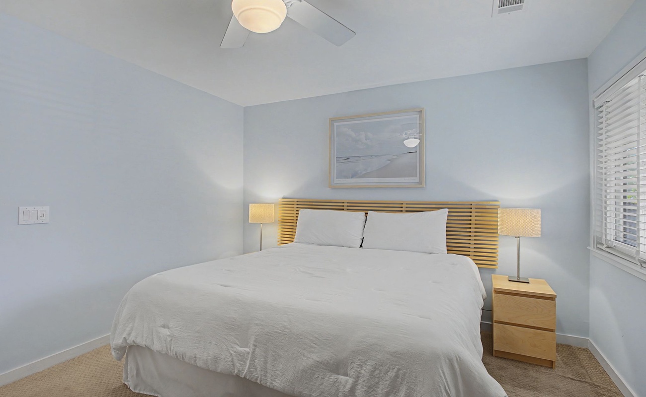 Drift off in your serene bedroom with plush bedding, gentle lighting, and calming coastal artwork creating the perfect restful retreat.