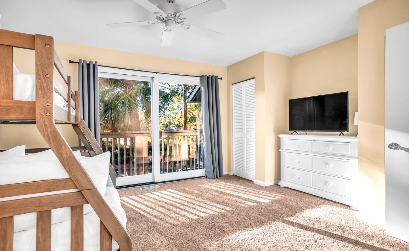 Relax in your bright bedroom with bunk beds, flat-screen TV, and private balcony overlooking tropical palms.