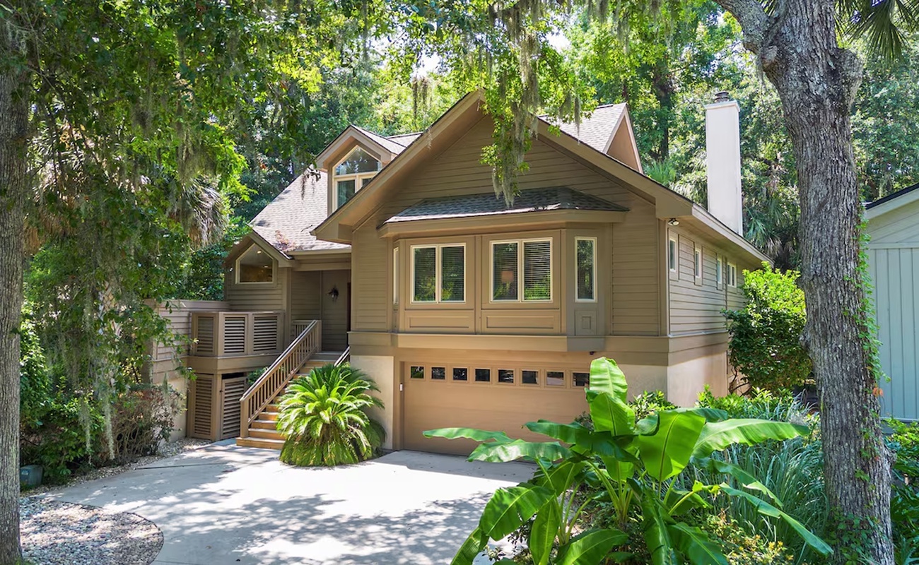 Charming forest retreat nestled among towering trees with tropical landscaping and peaceful setting.