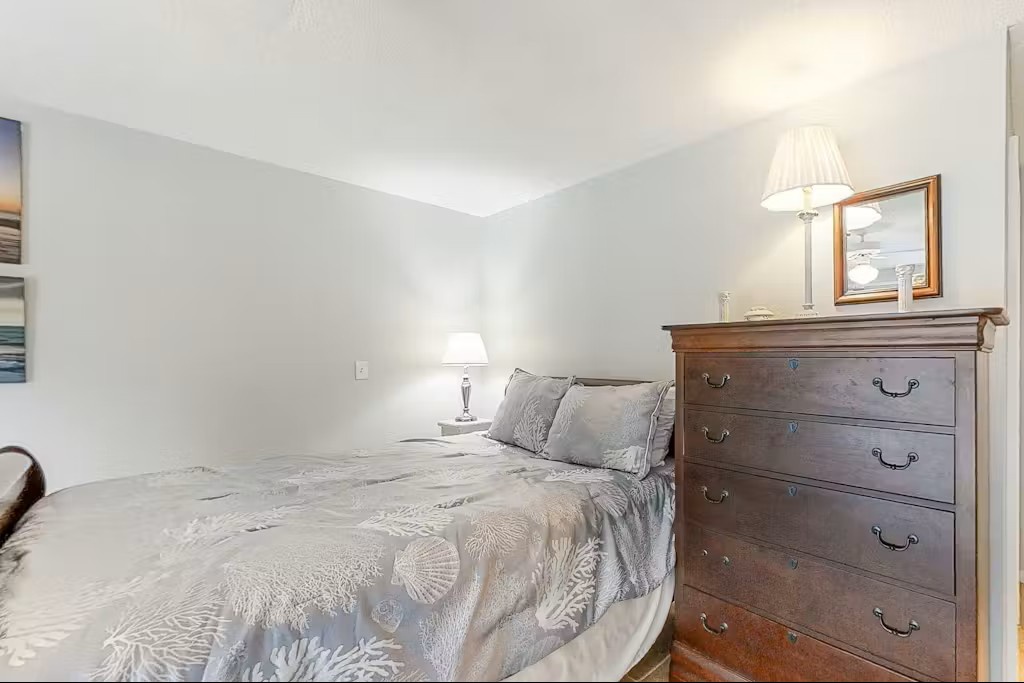 Rest peacefully in your serene bedroom, featuring elegant linens and classic furnishings for the perfect night's sleep.