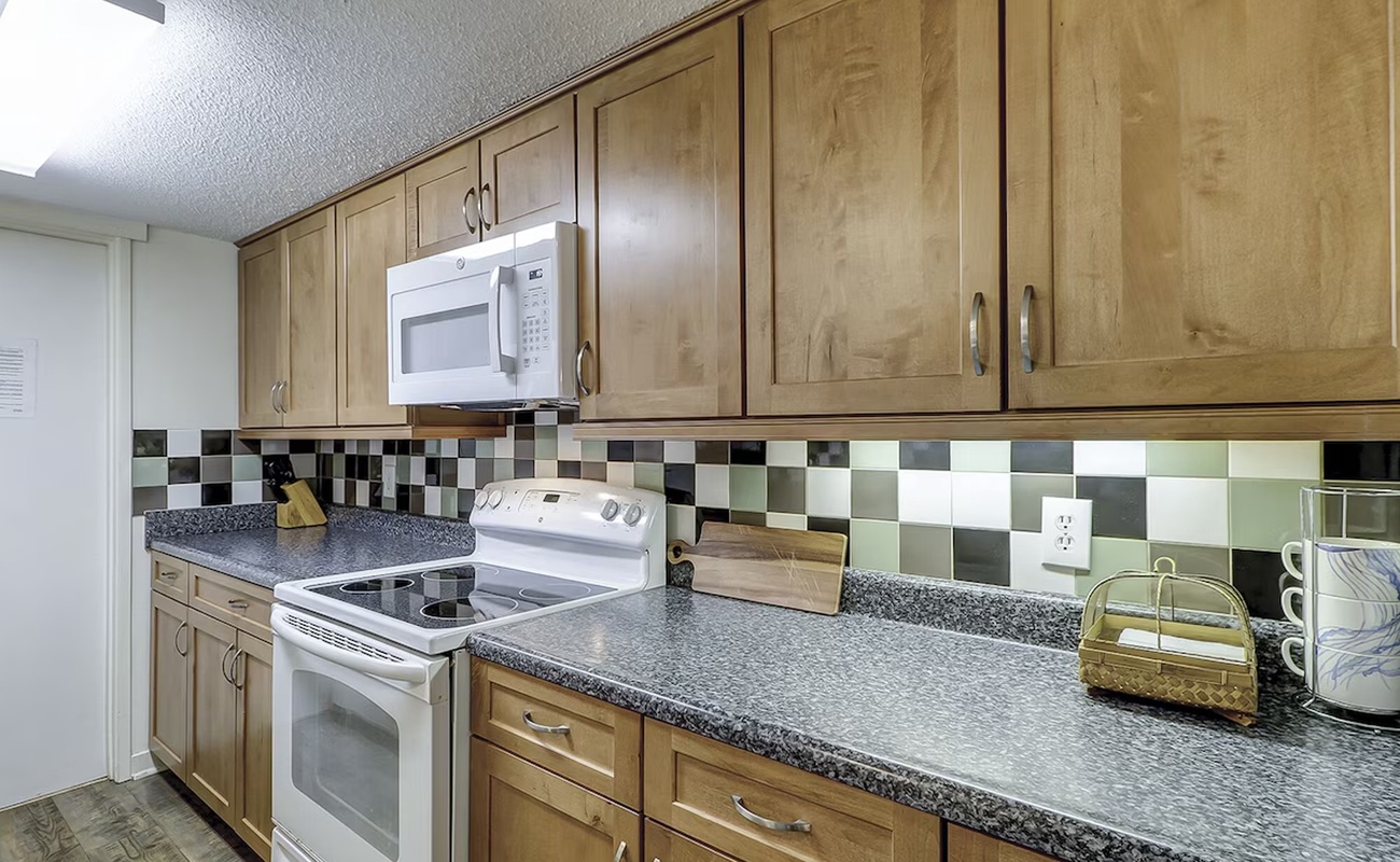 Your fully equipped kitchen features warm wood cabinets, granite countertops, and modern appliances—perfect for whipping up morning coffee or evening meals.
