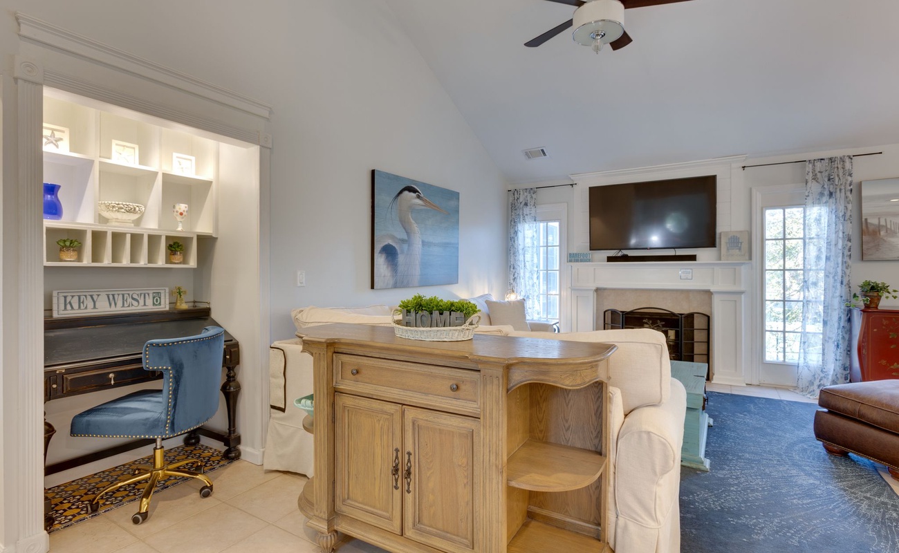 Relax in your bright coastal living room with sofa table workspace, built-in shelving, and fireplace for cozy evenings.