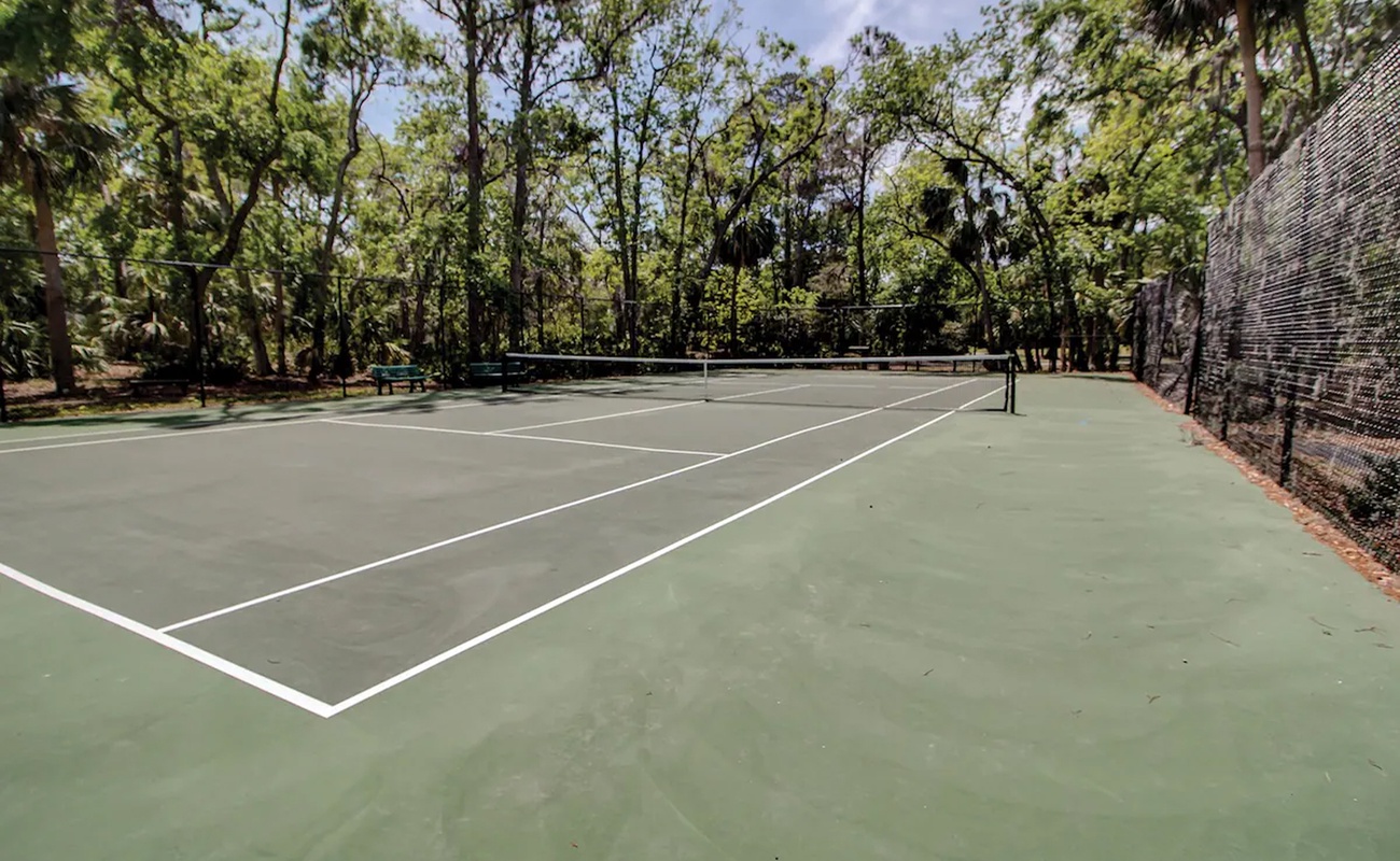 Serve up some friendly competition on your private tennis court, nestled among towering trees for the perfect shaded game.
