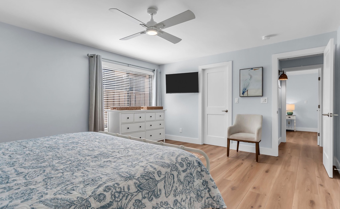 This spacious bedroom offers a tranquil escape with its crisp white palette, warm wood floors, and elegant coastal décor. It’s the perfect place to recharge after a sun-filled day on Hilton Head.