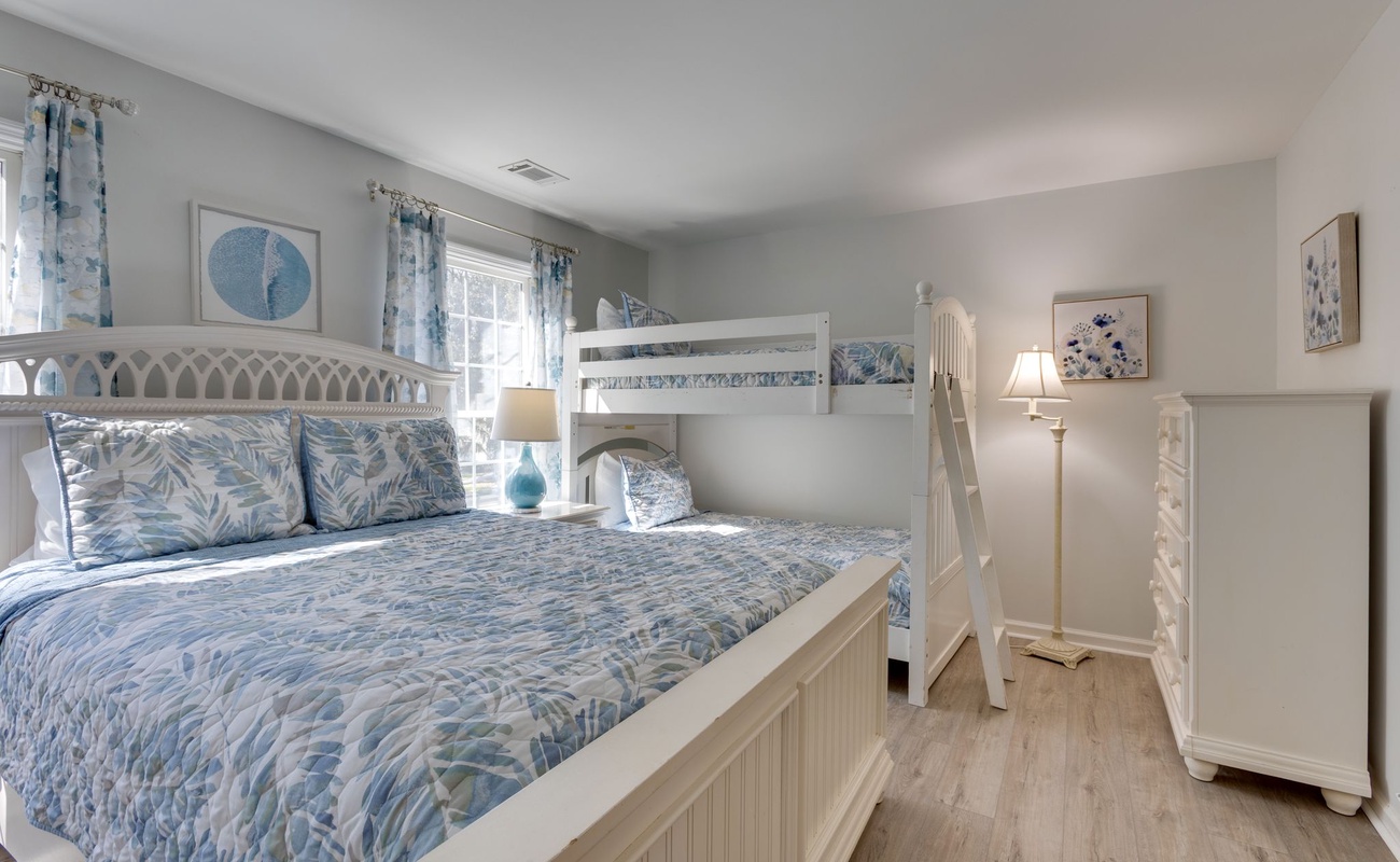 Your coastal-themed bedroom features a comfortable queen bed and cozy bunk bed, perfect for families seeking seaside tranquility.