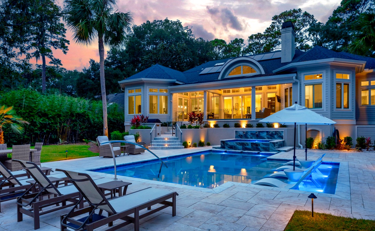 Luxurious Private Backyard with Pool, Ample Seating, and Screened in Porch at Sunset