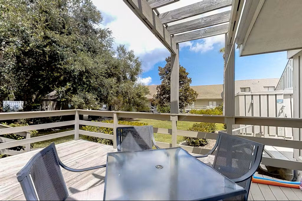 Step onto your private balcony where comfortable outdoor dining awaits, overlooking peaceful gardens and residential surroundings.