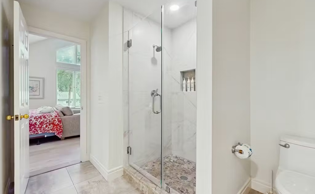 Step into your private spa-like retreat with marble walls and spacious glass shower after exploring the day.