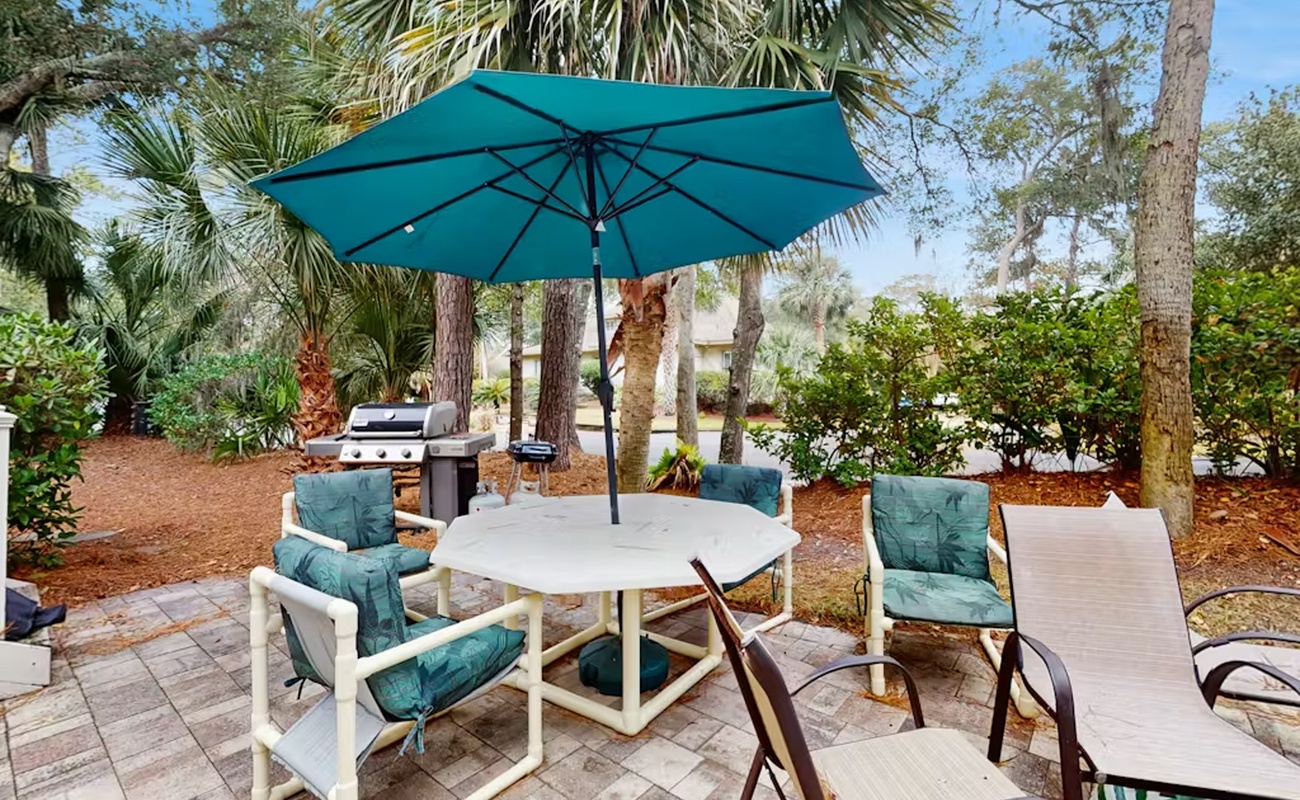 Gather around your private patio table under swaying palms, where teal cushions invite lazy afternoons and the grill awaits your culinary adventures.