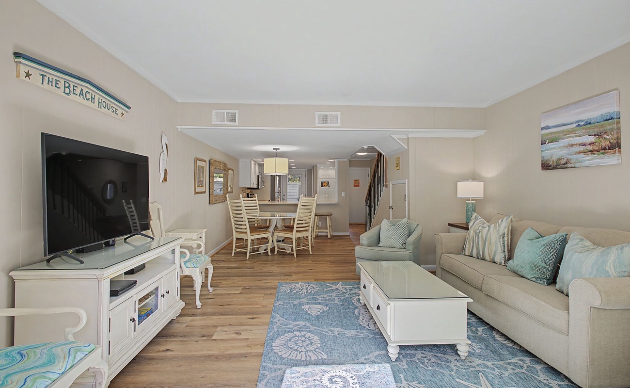 Relax in your coastal living space with comfortable seating, beachy blues, and entertainment center - perfect for unwinding.