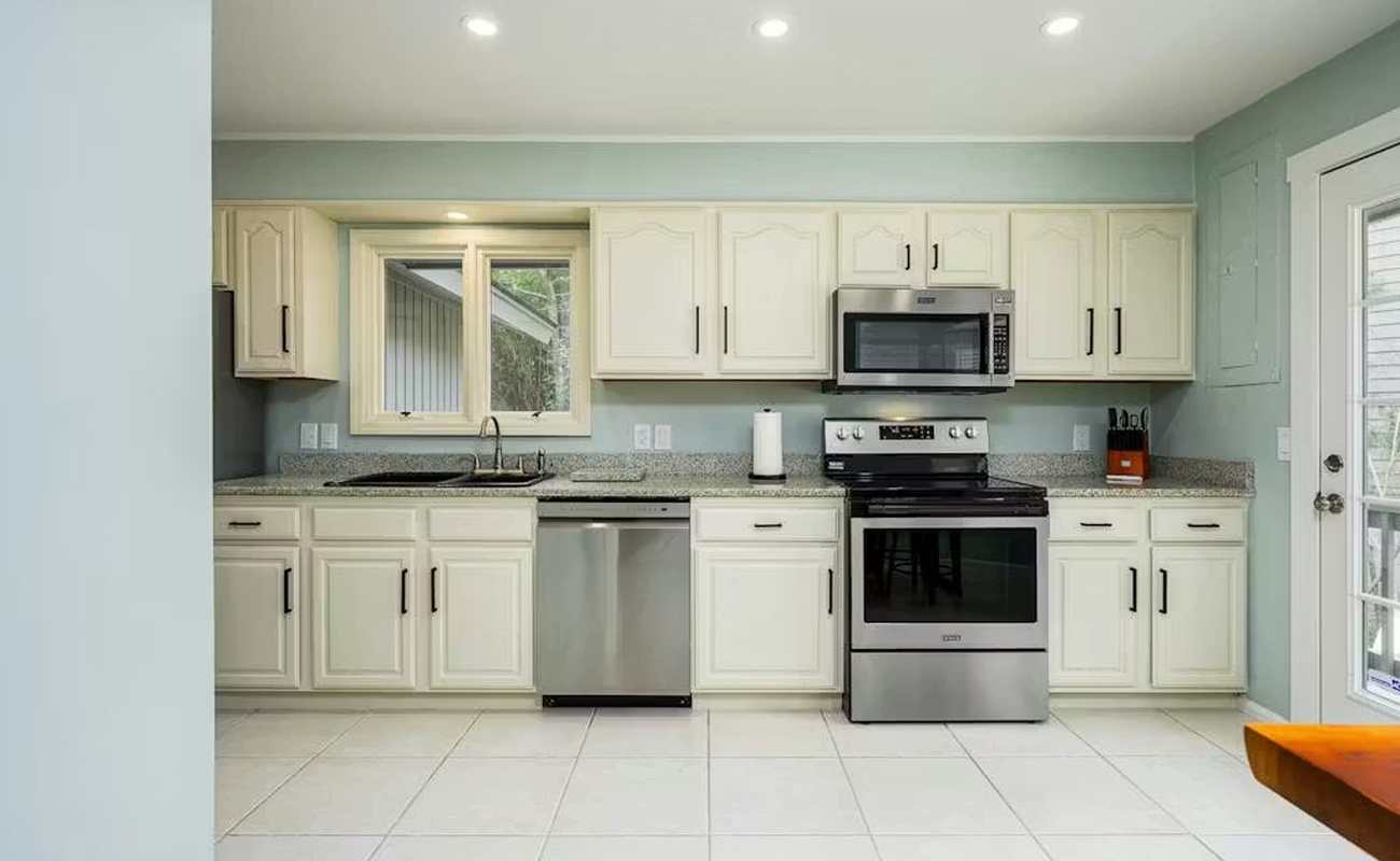 Your fully equipped kitchen awaits with modern stainless steel appliances, granite countertops, and bright white cabinetry for all your culinary adventures.
