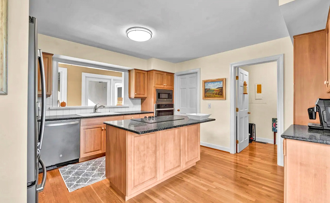 Step into your spacious kitchen with warm wood cabinetry, granite countertops, and a center island perfect for meal prep.