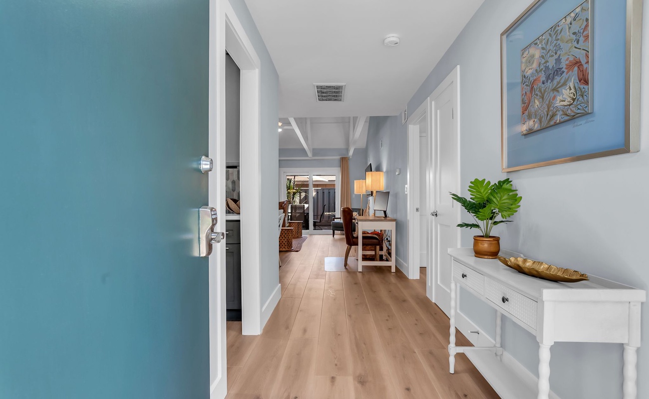 Step into your bright, welcoming hallway where coastal blues meet warm wood floors, leading you to cozy living spaces ahead.