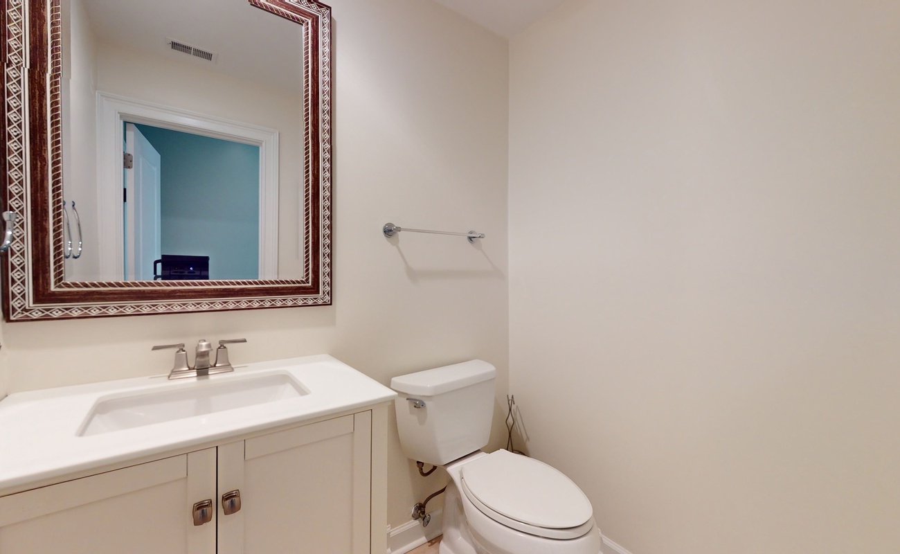 Your private powder room features elegant details with a beautiful decorative mirror and pristine fixtures for your convenience.