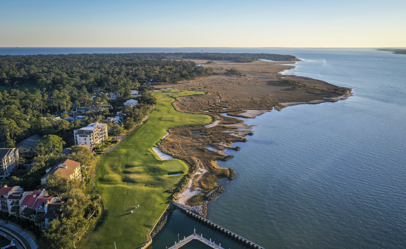 Stunning aerial view showcases the property's prime coastal location, featuring championship golf course fairways stretching to pristine oceanfront marshlands.