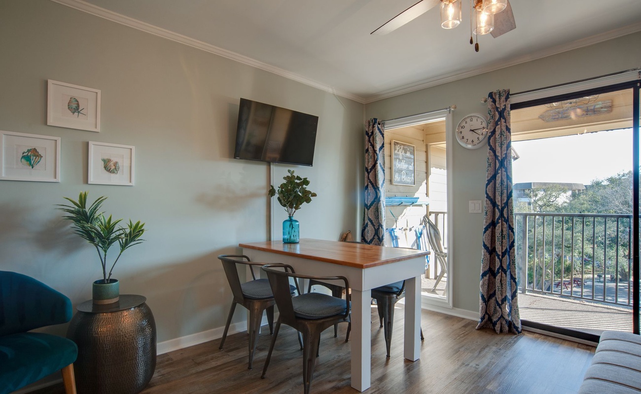 Your bright dining space features modern seating and opens to a private balcony with views of the surrounding area.