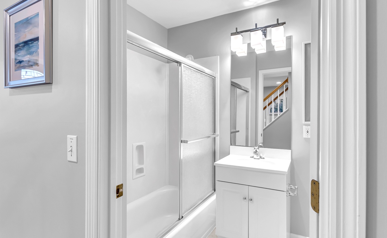 Step into your pristine bathroom with gleaming fixtures, modern vanity, and spacious shower-tub combo perfect for unwinding after exploring.