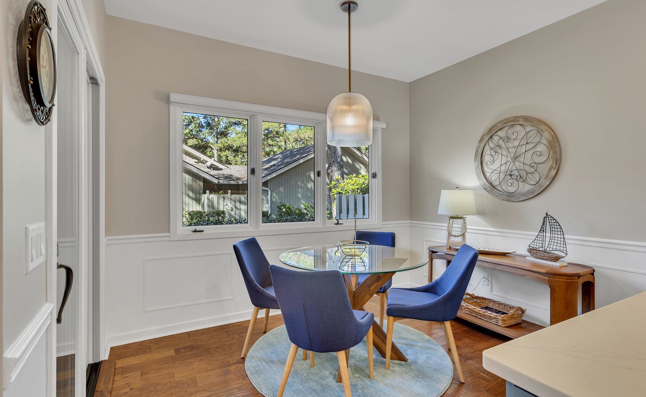 Gather around your elegant glass dining table where natural light streams through large windows, creating the perfect spot for memorable meals.