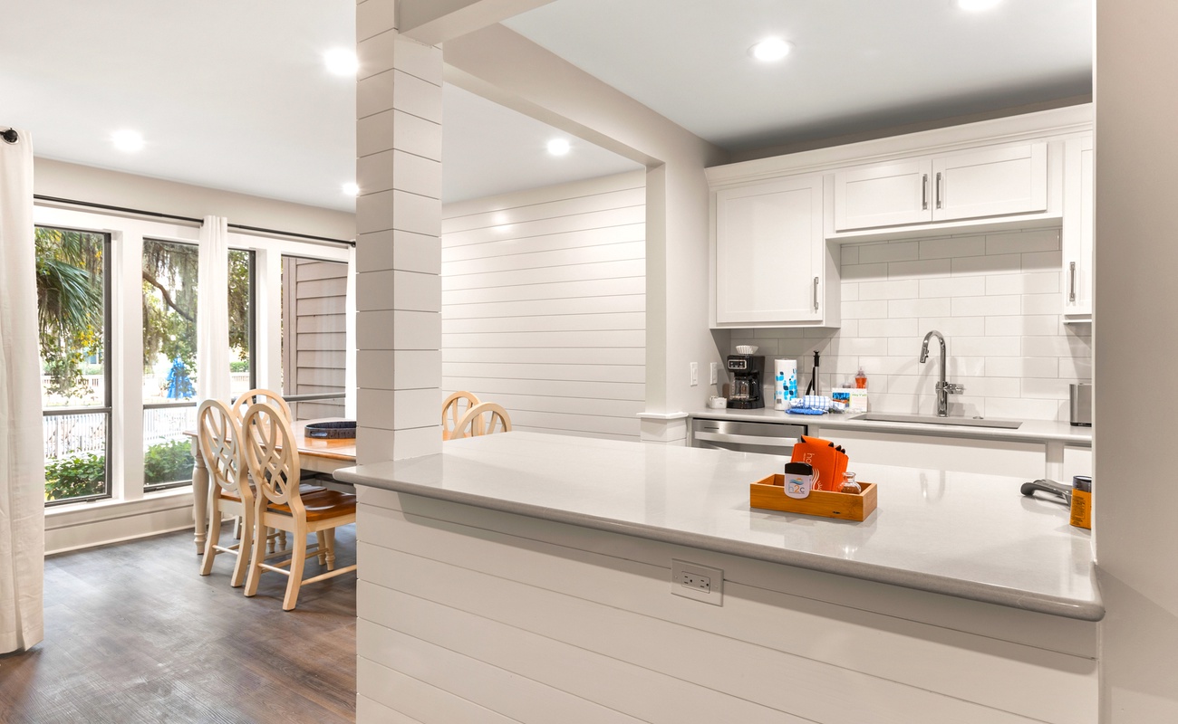 Cook and gather in your bright, modern kitchen featuring pristine white cabinetry, gleaming countertops, and a welcoming breakfast bar.