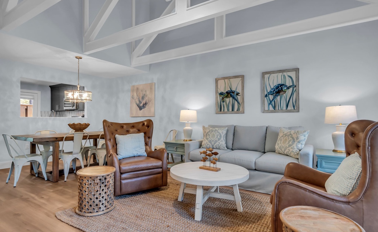 Relax in your coastal-chic living space with soaring beams, leather chairs, and soft blues creating the perfect beach retreat.