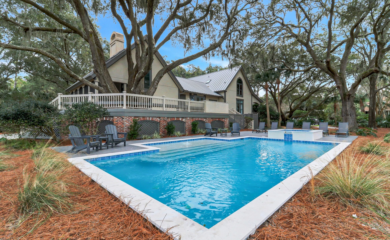 Jump into your private pool paradise, surrounded by majestic oak trees and elegant outdoor seating areas perfect for relaxation.