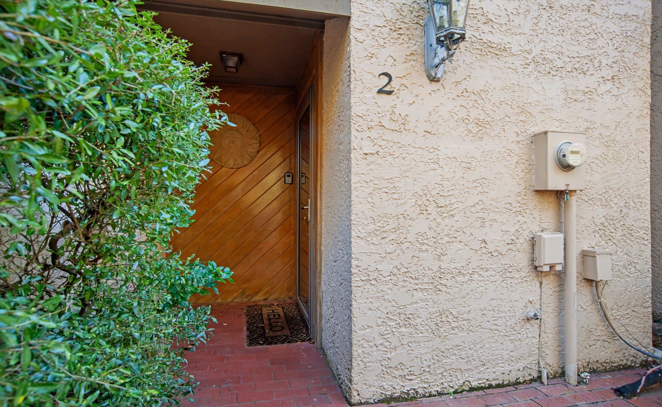 Property entrance marked as unit 2 with traditional lantern lighting and private brick pathway access.