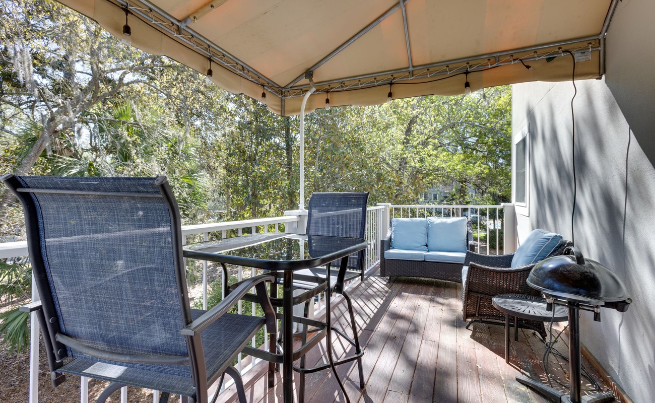 Unwind on your private covered balcony with comfortable seating and peaceful treetop views—perfect for morning coffee or evening relaxation.