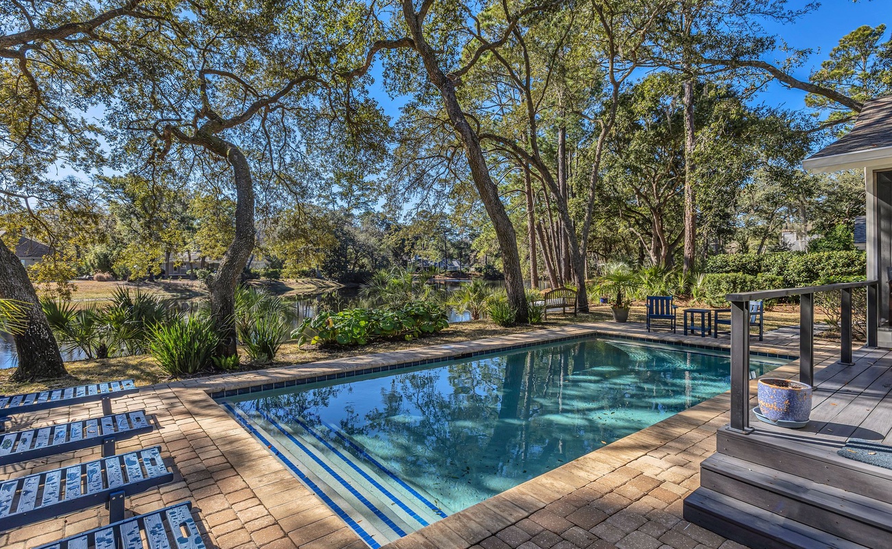 Sparkling pool nestled among towering oaks creates your private outdoor sanctuary for relaxation and recreation.