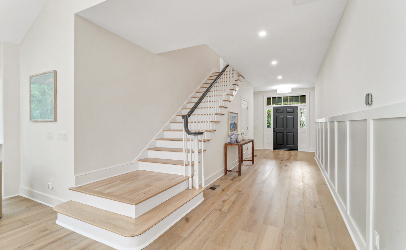 Step into your elegant foyer with warm hardwood floors and soaring ceilings that create an instantly welcoming atmosphere.