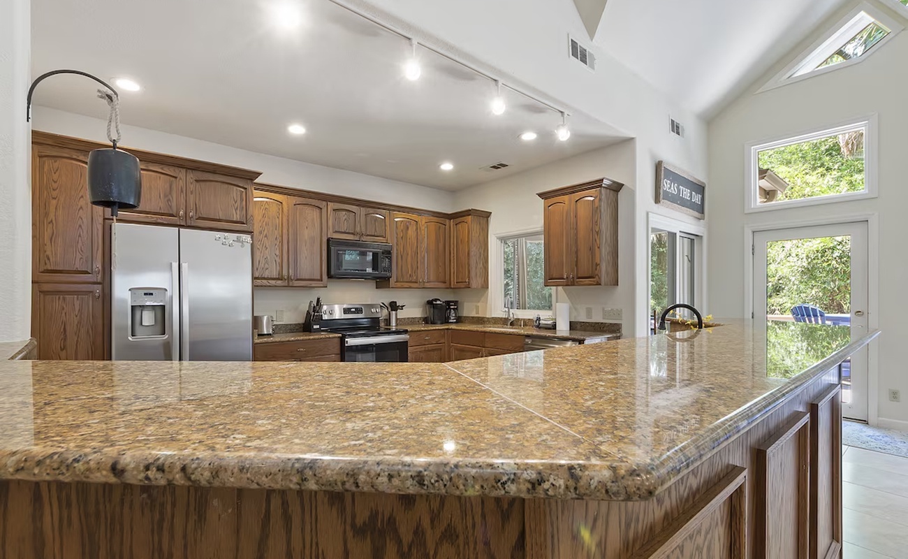 Your spacious kitchen awaits with granite countertops, premium appliances, and abundant natural light streaming through windows.