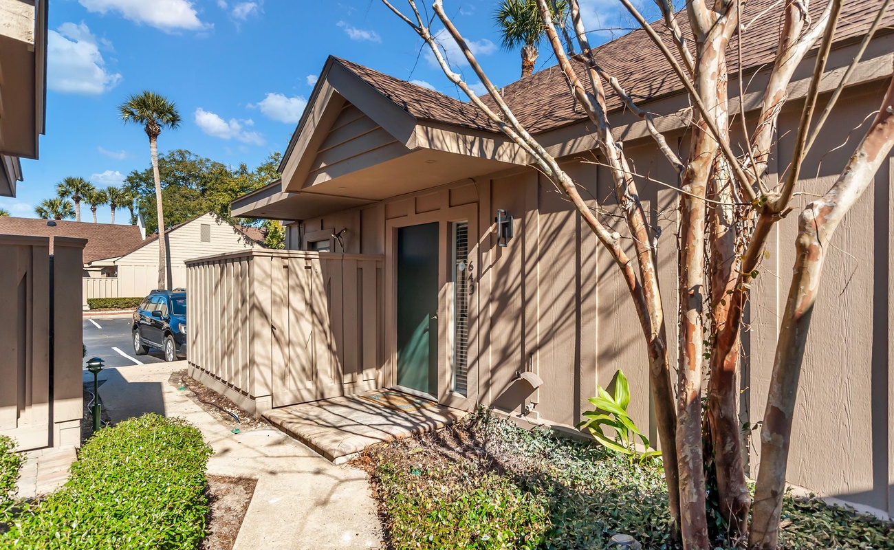 A modern townhouse featuring tropical landscaping and convenient parking in a peaceful residential setting.